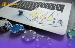 An image of playing cards, chips, and dice with a laptop