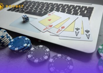 An image of playing cards, chips, and dice with a laptop